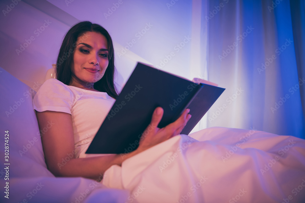 Low below angle view portrait of her she nice attractive lovely charming sweet calm peaceful girl lying in bed reading novel story spending night in illuminated room house hotel flat apartment Low below angle view portrait of her she nice attractive lovely charming sweet calm peaceful girl lying in bed reading novel story spending night in illuminated room house hotel flat apartment