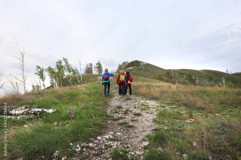 Obraz premium Tourists go on a footpath uphill