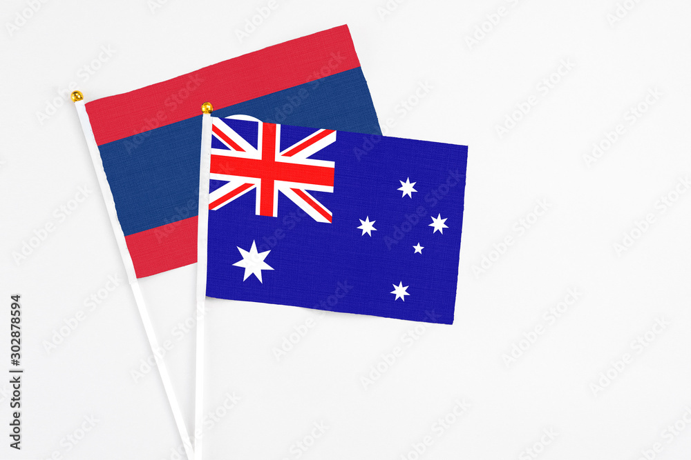 Fototapeta premium Australia and Laos stick flags on white background. High quality fabric, miniature national flag. Peaceful global concept.White floor for copy space.