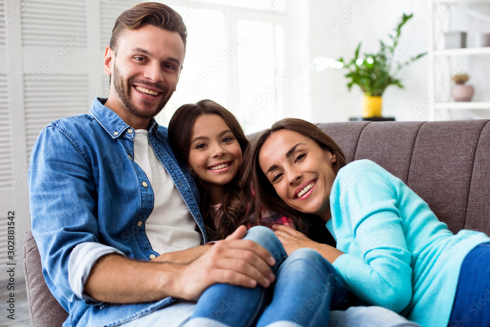 Tender hugs. Close up photo of handsome man and his gorgeous wife, who are relaxing in their modern apartment with their little cute kid. Tender hugs. Close up photo of handsome man and his gorgeous wife, who are relaxing in their modern apartment with their little cute kid.