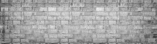 Wide gray brick wall texture. Rough light grey brickwork. Old cracked blocks panorama. Retro grunge widescreen background