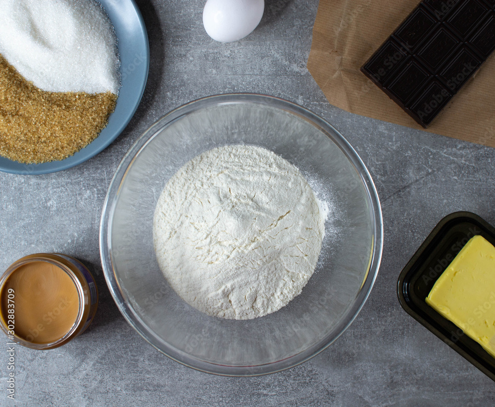 Ingredients for baking - flour, sugar, butter, plum, chocolade. stone or slate background.Top view. Ingredients for baking - flour, sugar, butter, plum, chocolade. stone or slate background.Top view.