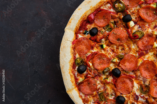 Close up view of pizza sicilian with salami, zucchini, jalapeno and bell pepper photo