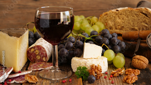 red wine with sausage, cheese, bread and grapes