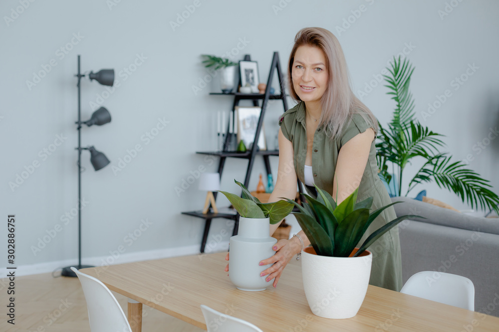 Blondie woman at home. Taking care of house plants. Blondie woman at home. Taking care of house plants.