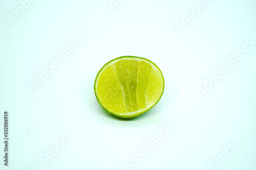 One piece of half sliced fresh green lime isolated on white background