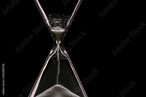 Crystal hourglass on dark background, closeup