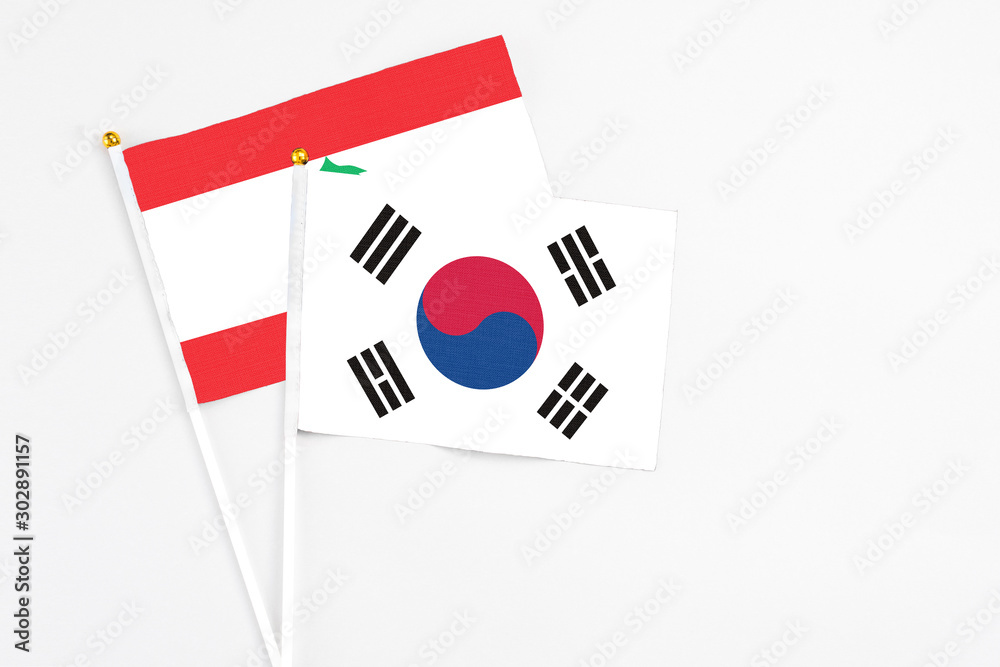 South Korea and Lebanon stick flags on white background. High quality fabric, miniature national flag. Peaceful global concept.White floor for copy space.