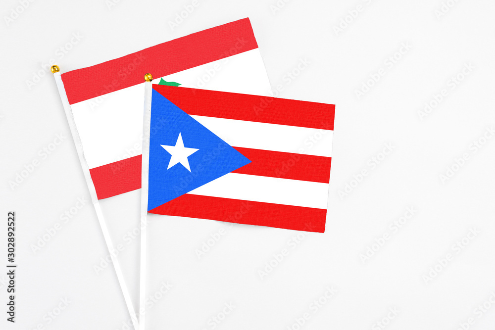 Puerto Rico and Lebanon stick flags on white background. High quality fabric, miniature national flag. Peaceful global concept.White floor for copy space.