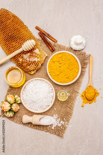 Personal care with natural ingredients. Healthy spa concept. Turmeric, sea salt, honey, cinnamon, oil. Stone concrete background
