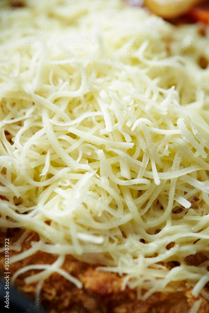 Shredded cheese on food, close up shot Shredded cheese on food, close up shot