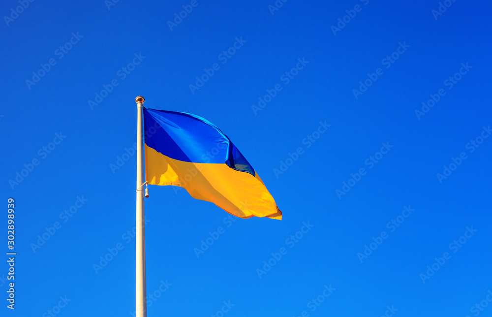 Ukrainian flag waving on blue sky background Ukrainian flag waving on blue sky background