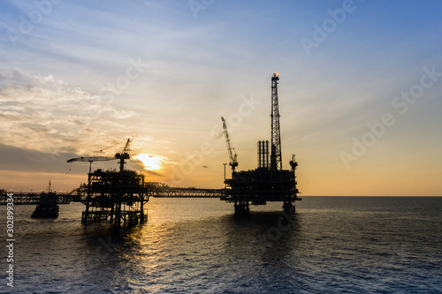 Silhouette of oil production platform during sunset at oil field