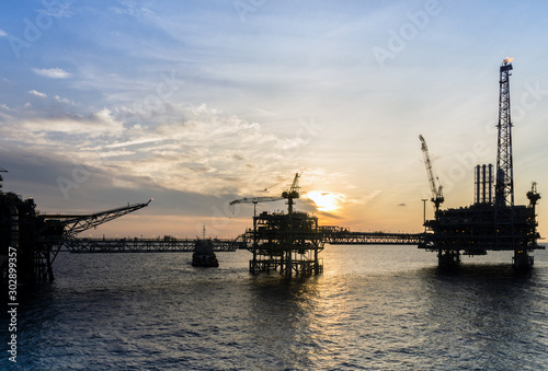 Silhouette of oil production platform during sunset at oil field