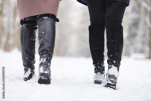 A young girl in a winter park on a walk. Christmas holidays in the winter forest. The girl enjoys winter in the park.