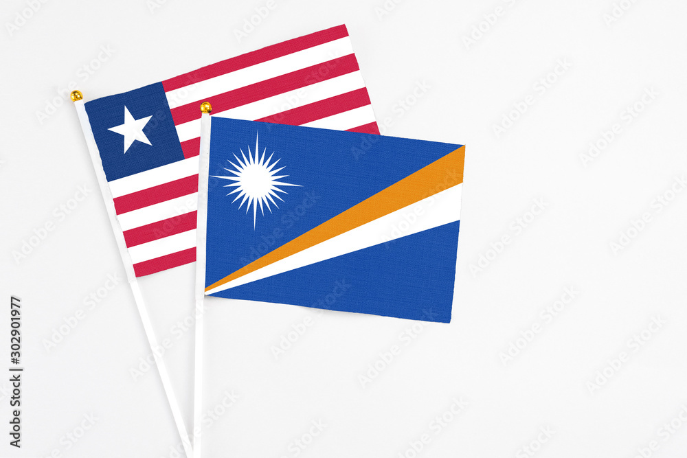 Marshall Islands and Liberia stick flags on white background. High quality fabric, miniature national flag. Peaceful global concept.White floor for copy space. Marshall Islands and Liberia stick flags on white background. High quality fabric, miniature national flag. Peaceful global concept.White floor for copy space.