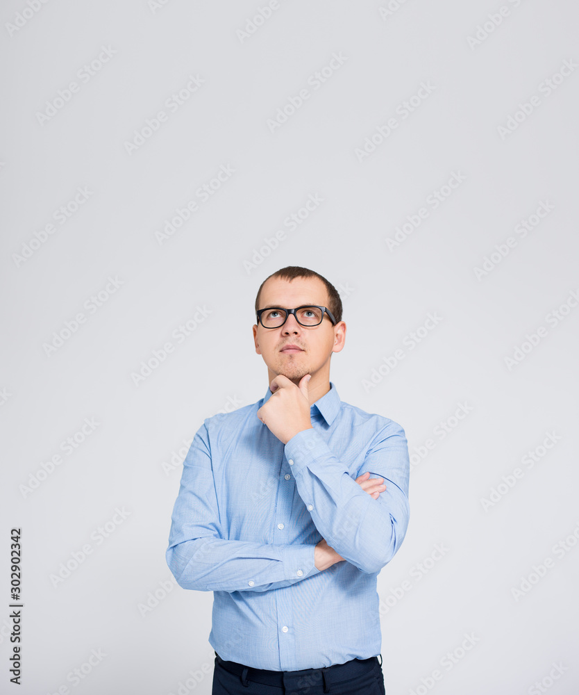 idea concept - portrait of young thinking businessman and copy space over gray background idea concept - portrait of young thinking businessman and copy space over gray background