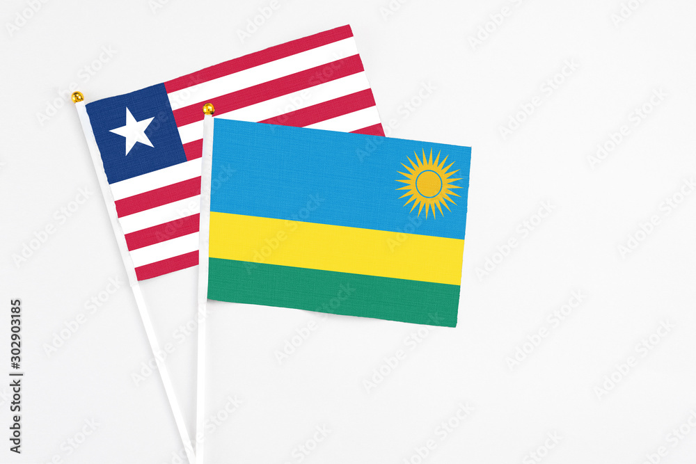Rwanda and Liberia stick flags on white background. High quality fabric, miniature national flag. Peaceful global concept.White floor for copy space. Rwanda and Liberia stick flags on white background. High quality fabric, miniature national flag. Peaceful global concept.White floor for copy space.