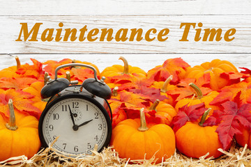 Maintenance Time message with a retro alarm clock with pumpkins and fall leaves