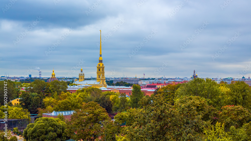 Beautiful panorama of the historic city center of St. Petersburg, Russia. Top view of the Peter and Paul Fortress and the cathedral with a golden spire. In the foreground is Alexander Park.