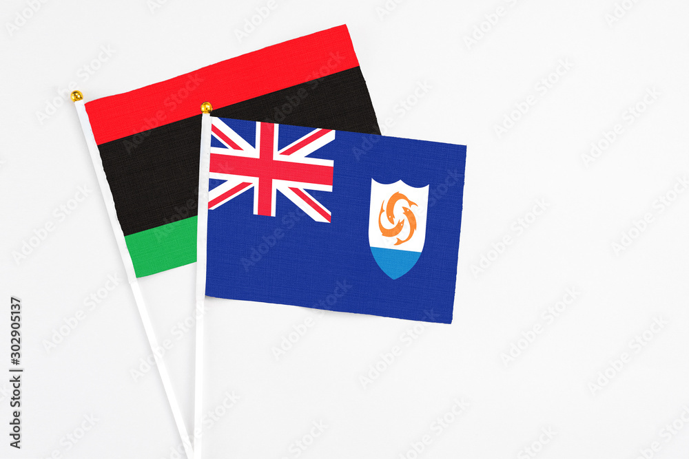 Fototapeta premium Anguilla and Libya stick flags on white background. High quality fabric, miniature national flag. Peaceful global concept.White floor for copy space.