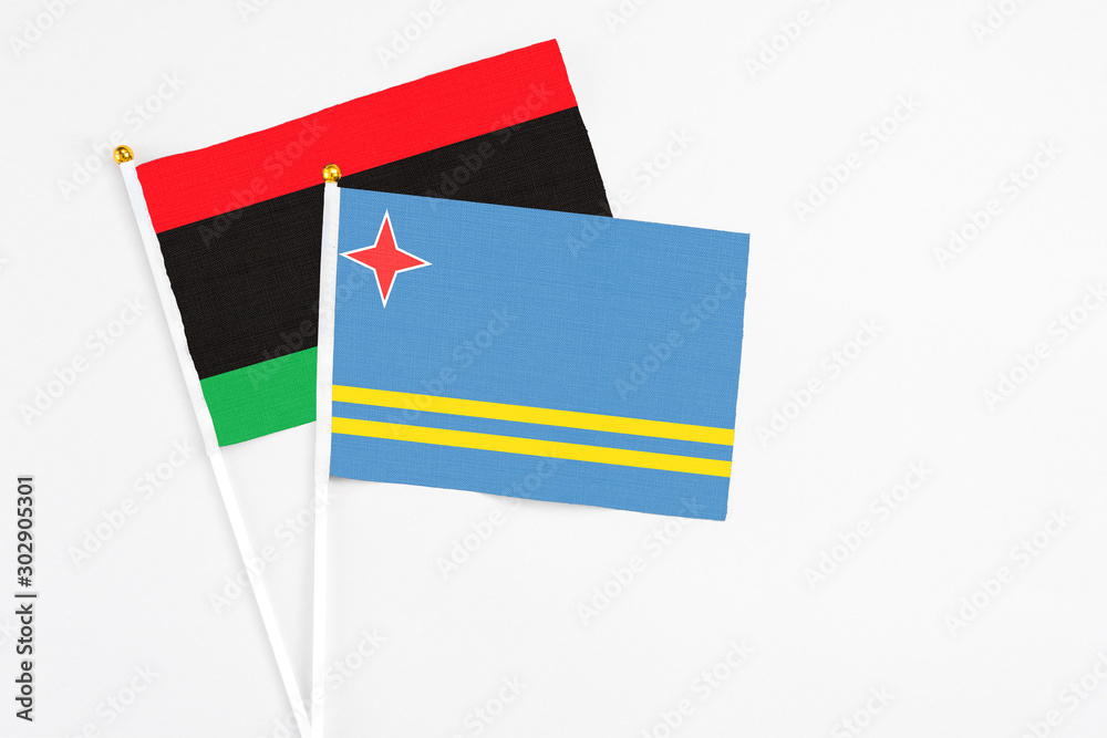 Aruba and Libya stick flags on white background. High quality fabric, miniature national flag. Peaceful global concept.White floor for copy space. Aruba and Libya stick flags on white background. High quality fabric, miniature national flag. Peaceful global concept.White floor for copy space.