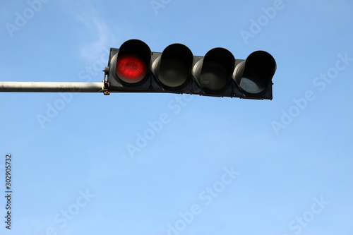 Horizontal traffic lights on red against a blue sky background