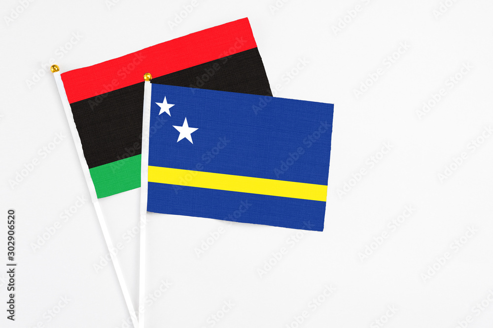 Curacao and Libya stick flags on white background. High quality fabric, miniature national flag. Peaceful global concept.White floor for copy space. Curacao and Libya stick flags on white background. High quality fabric, miniature national flag. Peaceful global concept.White floor for copy space.