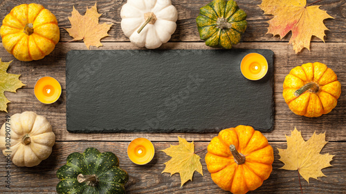 Thanksgiving background with pumpkins, autumn leaves and candles