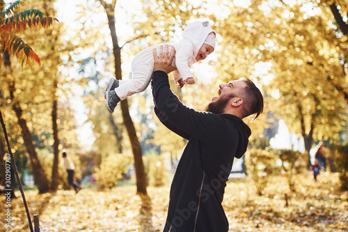 Father in casual clothes with his child is in the beautiful autumn park © standret