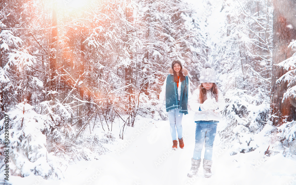 Young family for a walk. Mom and daughter are walking in a winter park. Young family for a walk. Mom and daughter are walking in a winter park.