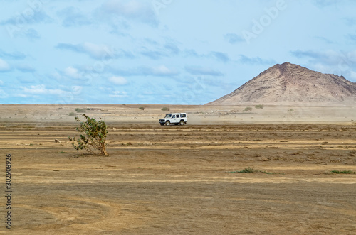 Crossover car driving over the arid landscape near Buracona on the island Sal, Cape Verde photo