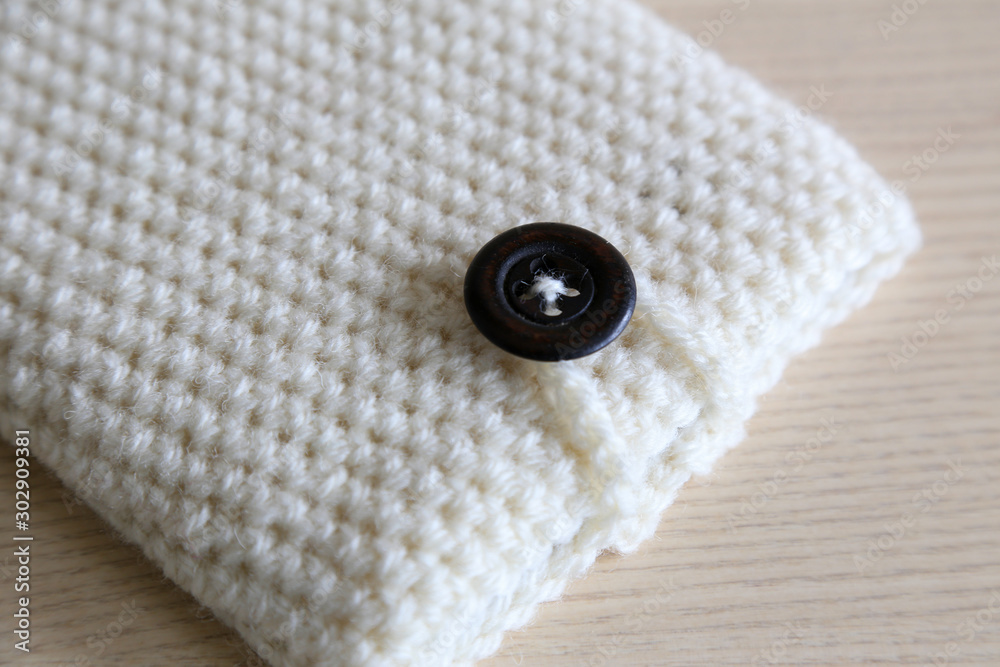 handmade crochet tablet or phone case on a wooden background. crafting ideas handmade crochet tablet or phone case on a wooden background. crafting ideas