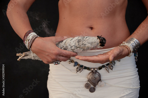 Tablou pe pânză Smudge stick held by priestess hands.