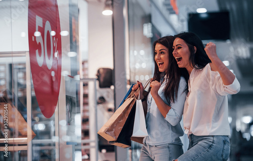 Feeling excited. Two young women have a shopping day together in the supermarket photo
