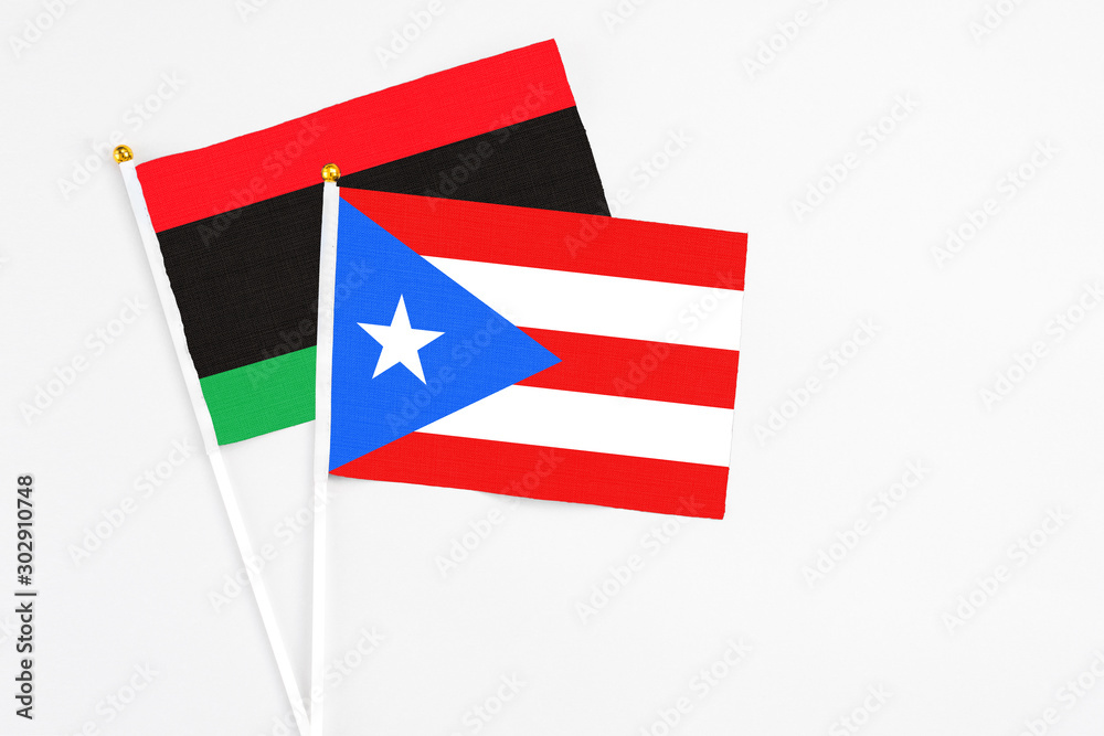 Puerto Rico and Libya stick flags on white background. High quality fabric, miniature national flag. Peaceful global concept.White floor for copy space. Puerto Rico and Libya stick flags on white background. High quality fabric, miniature national flag. Peaceful global concept.White floor for copy space.