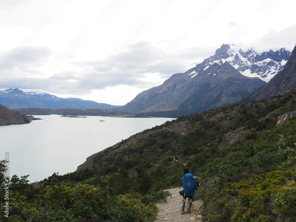 A man climber walking on the ground looking at the beautiful nature, Torres del Paine trekking, Torres del Paine National Park, Patagonia, Chile