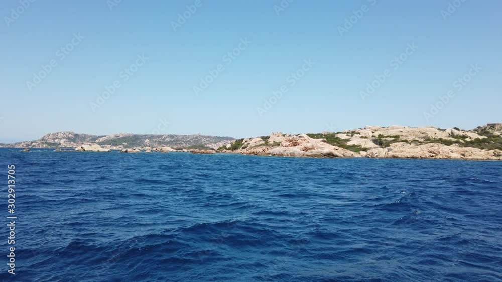 blue water waves passing by, island in the background, wide shot, La Maddalena, Sardinia blue water waves passing by, island in the background, wide shot, La Maddalena, Sardinia