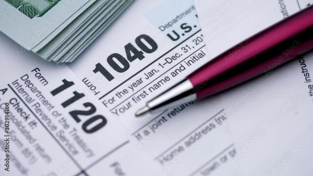 USA tax form 1040, 1120, and dollar bills, close up USA tax form 1040, 1120, and dollar bills, close up