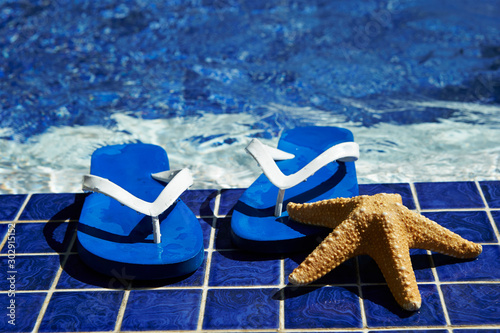 Flip flops with starfish in swimming pool