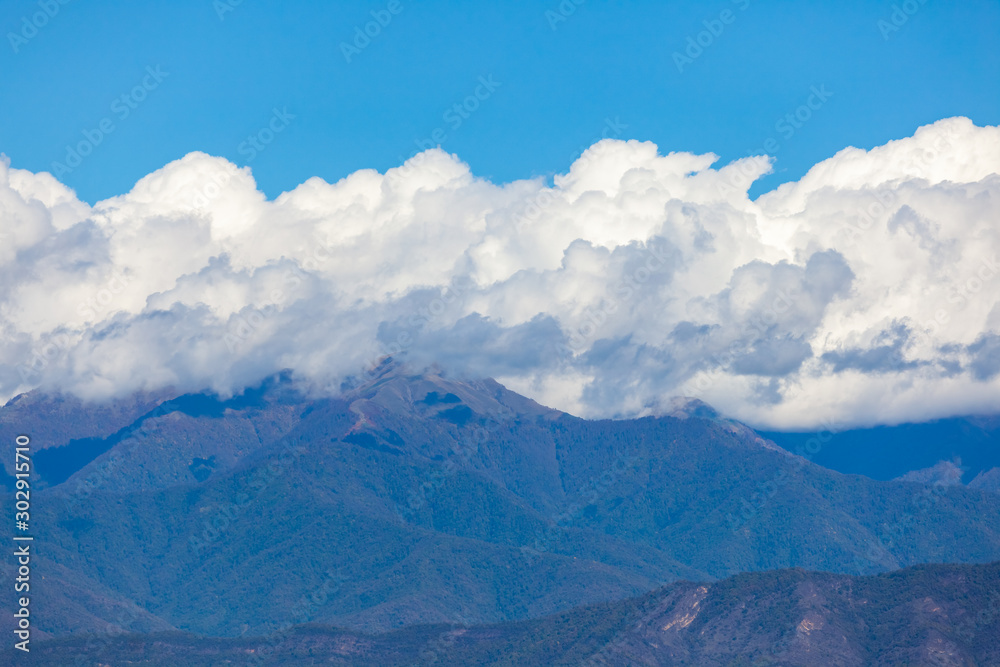 View of the peaks of the mountains in Kakheti and white clouds on blue sky.