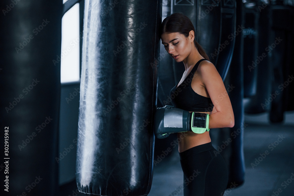Young woman in sportive wear is in the gym having exercise day. Conception of boxing