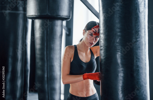 Young woman in sportive wear is in the gym having exercise day. Conception of boxing