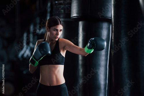 Young woman in sportive wear is in the gym having exercise day. Conception of boxing © standret