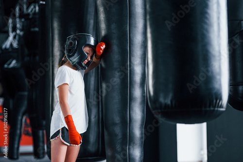 Young little girl in sportive wear and protective hat is in the gym have exercise day. Conception of boxing © standret