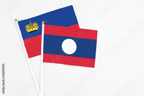 Free Download Laos and Liechtenstein stick flags on white background. High quality fabric, miniature national flag. Peaceful global concept.White floor for copy space. - GFXLoad