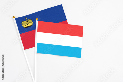Luxembourg and Liechtenstein stick flags on white background. High quality fabric  miniature national flag. Peaceful global concept.White floor for copy space.