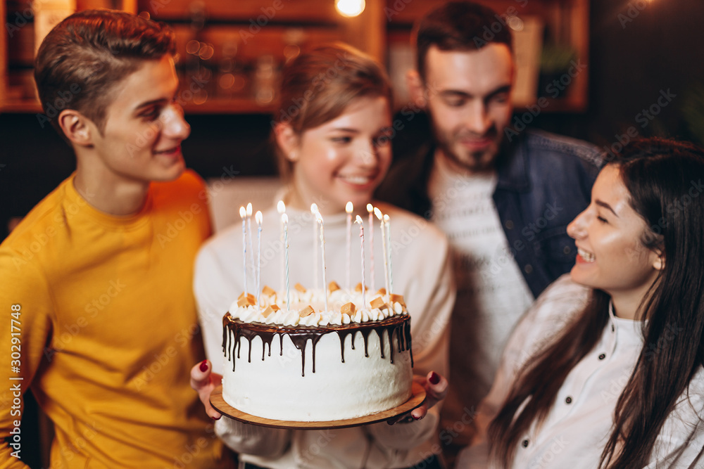 cheerful young company celebrates birthday and have a cake with candles cheerful young company celebrates birthday and have a cake with candles
