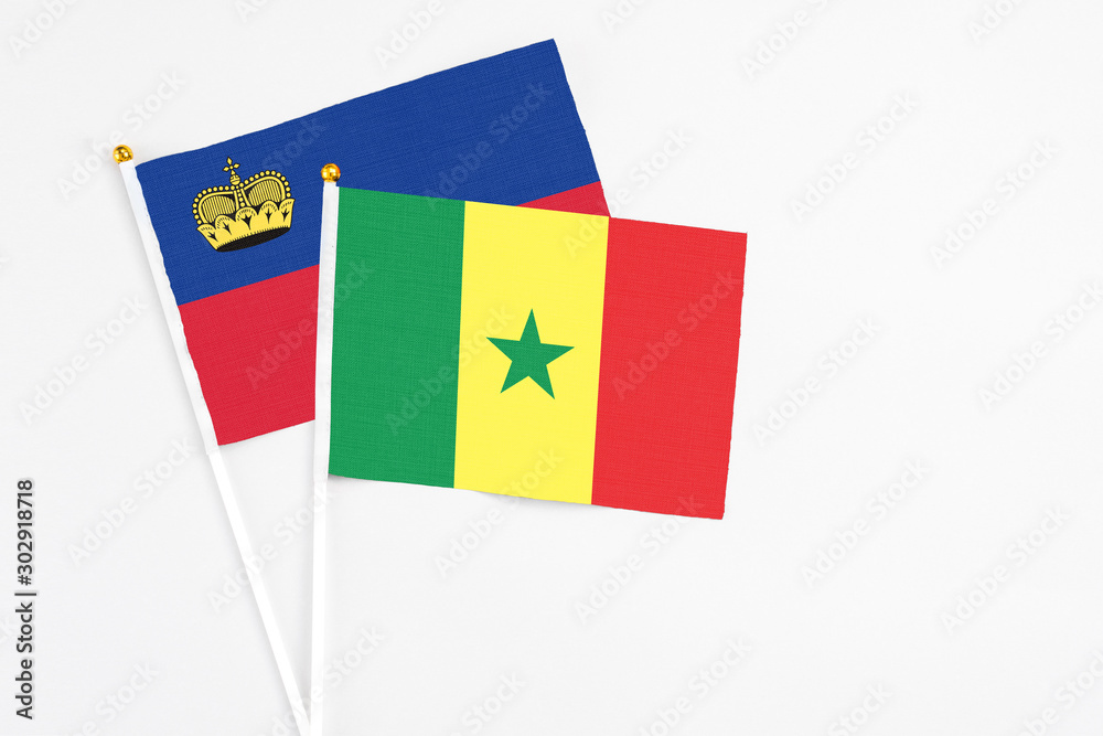 Senegal and Liechtenstein stick flags on white background. High quality fabric, miniature national flag. Peaceful global concept.White floor for copy space.