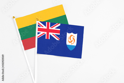 Anguilla and Lithuania stick flags on white background. High quality fabric, miniature national flag. Peaceful global concept.White floor for copy space.